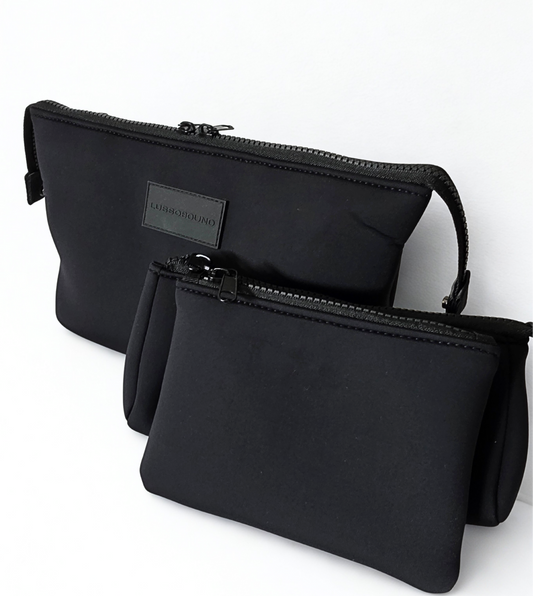 Two black travel make-up pouches with a visible brand label on a white background