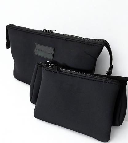 Two black travel make-up pouches with a visible brand label on a white background
